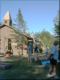 A Loader lifts shingles to the Church Roof