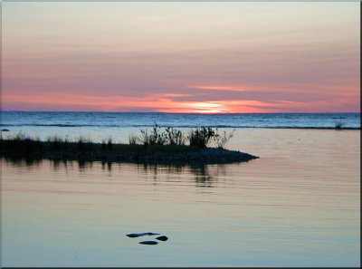 A still pool in the foreground echoes the sunset mood