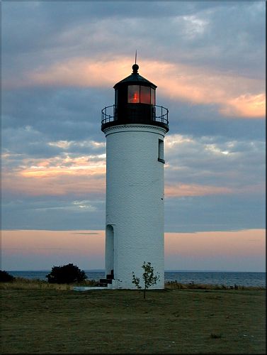 The harbor light, taken as the sun breaks through stormy clouds