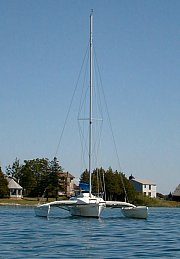 a trimaran sits on a buoy protected by the point